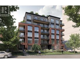 A modern apartment building with balconies and greenery on the roof.