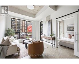 A living room with a couch, chair, and a bed.