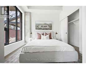 A bedroom with a large bed and a painting on the wall.