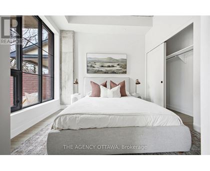 A bedroom with a large bed and a painting on the wall.