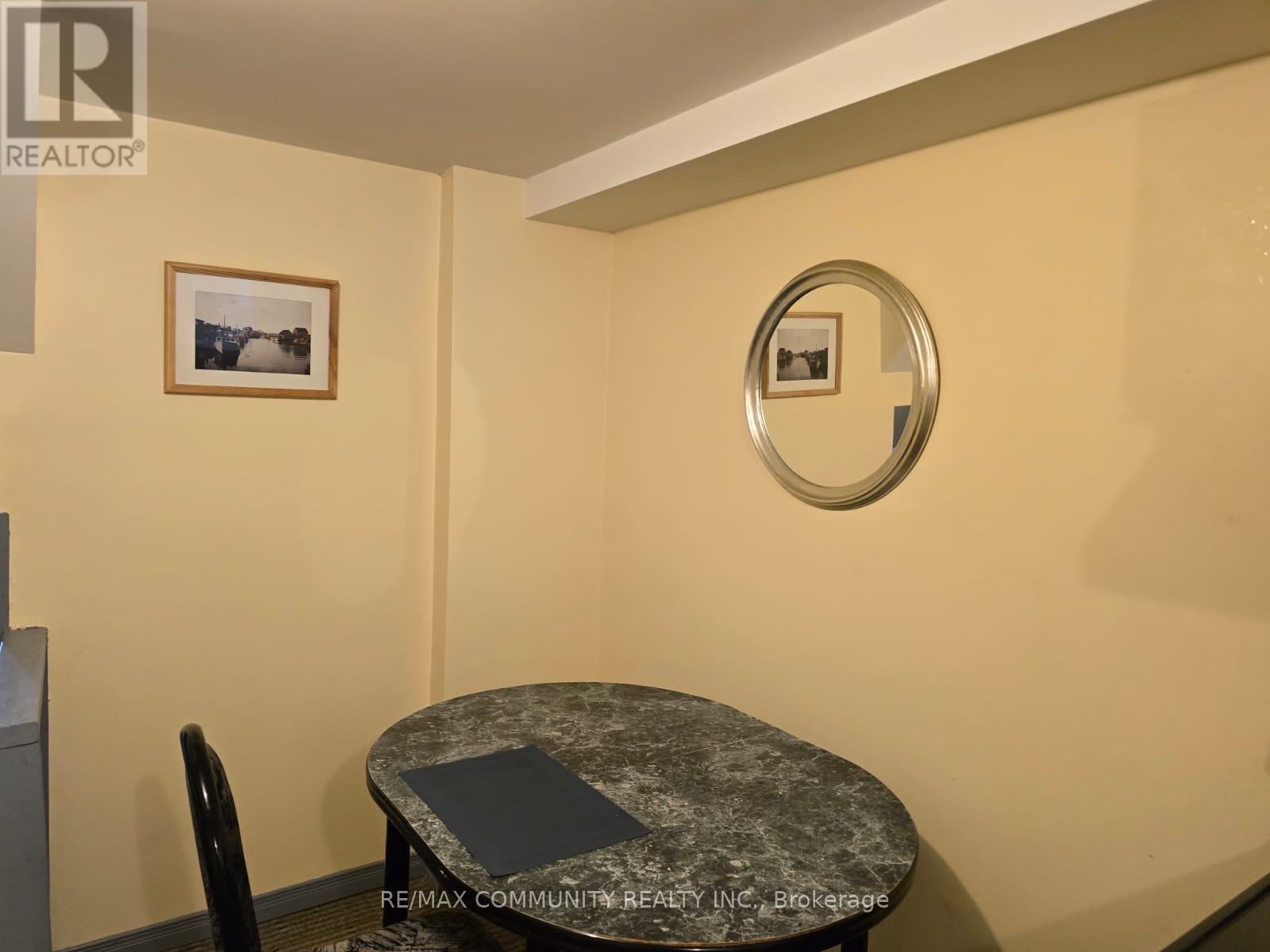 A small dining room with a round table and a single chair.