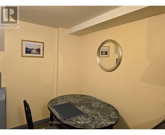 A small dining room with a round table and a single chair.