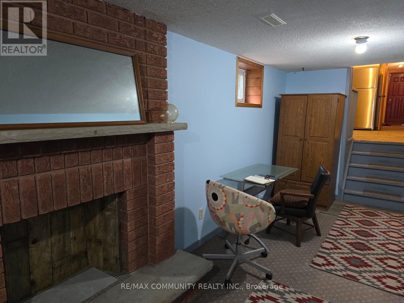 A room with a fireplace and a desk with a chair.