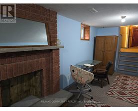 A room with a fireplace and a desk with a chair.