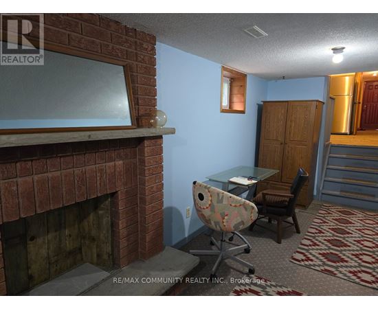A room with a fireplace and a desk with a chair.