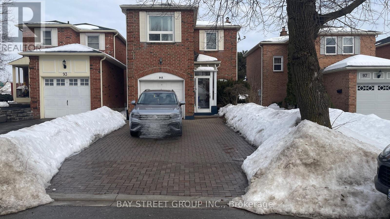 A car is parked in a driveway in front of a house.