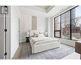 A bedroom with a large bed and a view of a construction site outside the window.