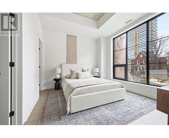 A bedroom with a large bed and a view of a construction site outside the window.