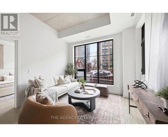 A well-lit, modern living room with a large window and a view of a building outside.