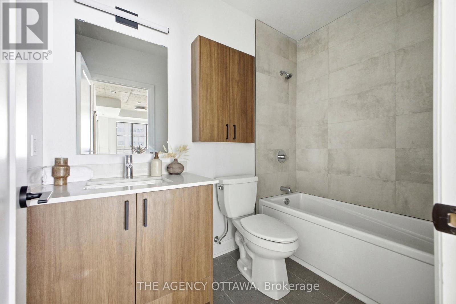 A bathroom with a toilet, sink, and bathtub.