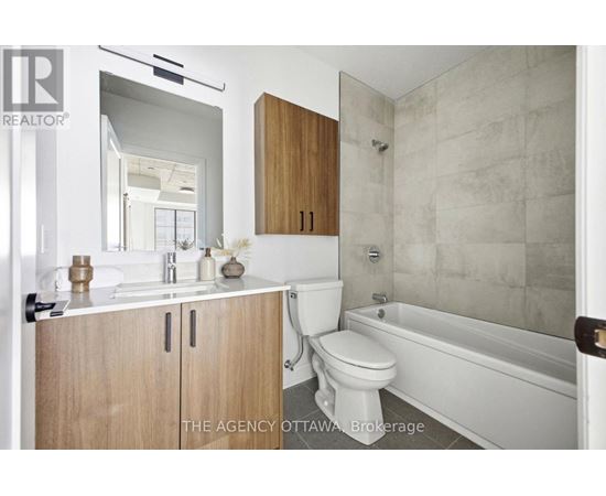 A bathroom with a toilet, sink, and bathtub.