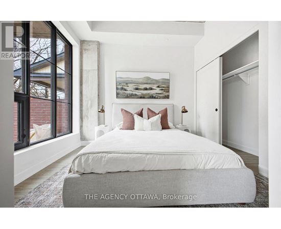 A bedroom with a large bed and a painting on the wall.