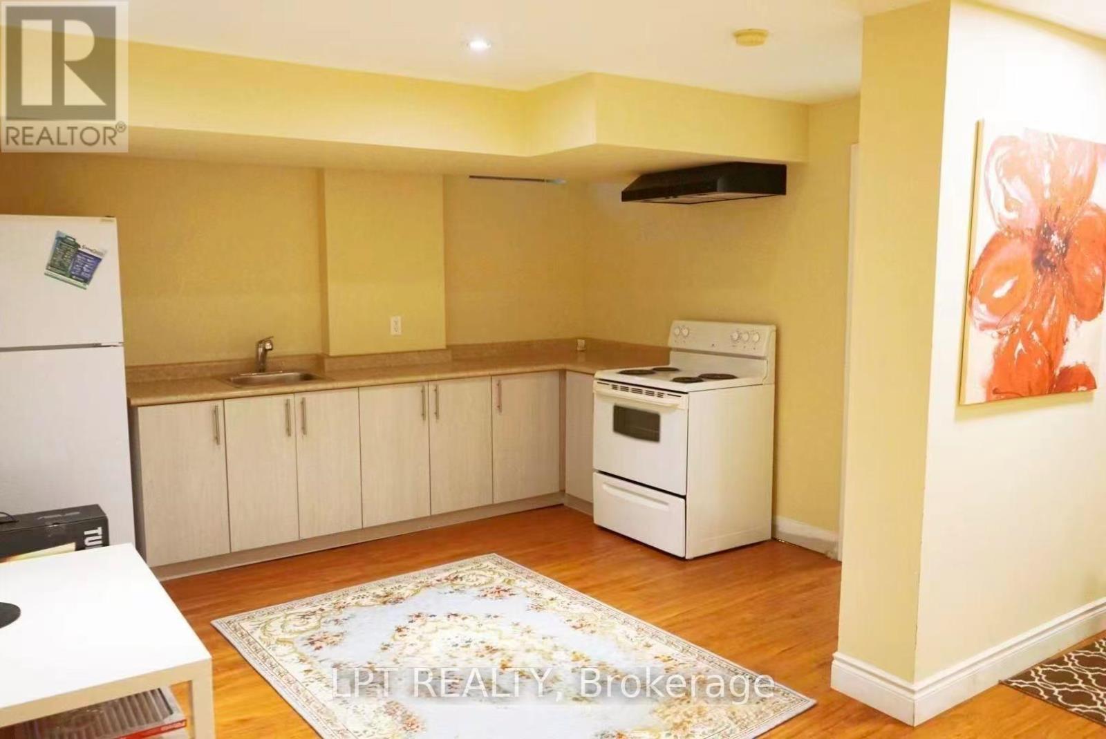 A kitchen with a refrigerator, oven, and cabinets.
