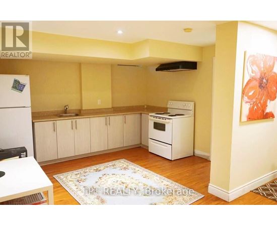 A kitchen with a refrigerator, oven, and cabinets.