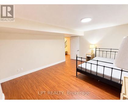A bedroom with a white bed, dresser, and rug.
