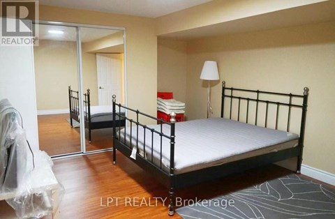 A bedroom with a black metal bed frame and a white mattress.