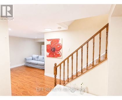 A living room with a couch and a flower painting on the wall.