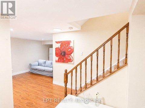 A living room with a couch and a flower painting on the wall.