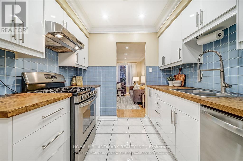 A kitchen with white cabinets and a wooden countertop.