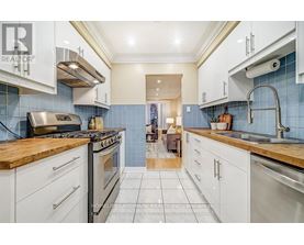 A kitchen with white cabinets and a wooden countertop.