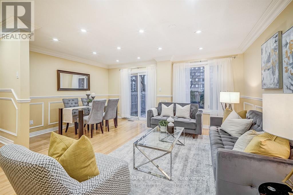 A living room with a grey couch, a grey coffee table, a grey chair, a grey dining table with grey chairs, a grey sofa, a grey rug, a grey wall, a grey floor, a grey ceiling,
