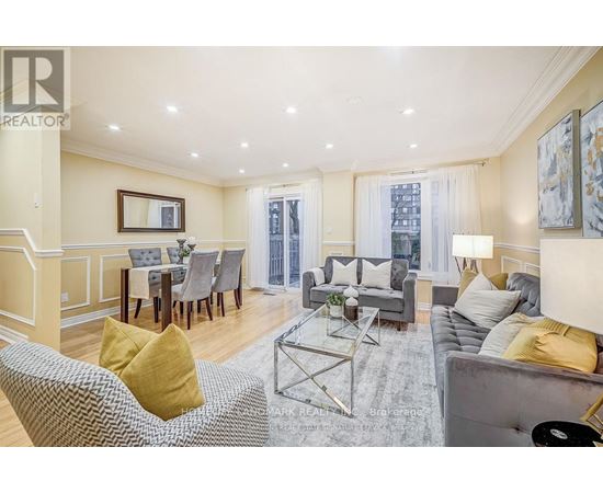 A living room with a grey couch, a grey coffee table, a grey chair, a grey dining table with grey chairs, a grey sofa, a grey rug, a grey wall, a grey floor, a grey ceiling,