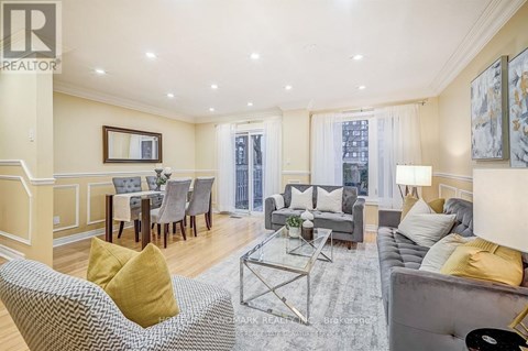A living room with a grey couch, a grey coffee table, a grey chair, a grey dining table with grey chairs, a grey sofa, a grey rug, a grey wall, a grey floor, a grey ceiling,