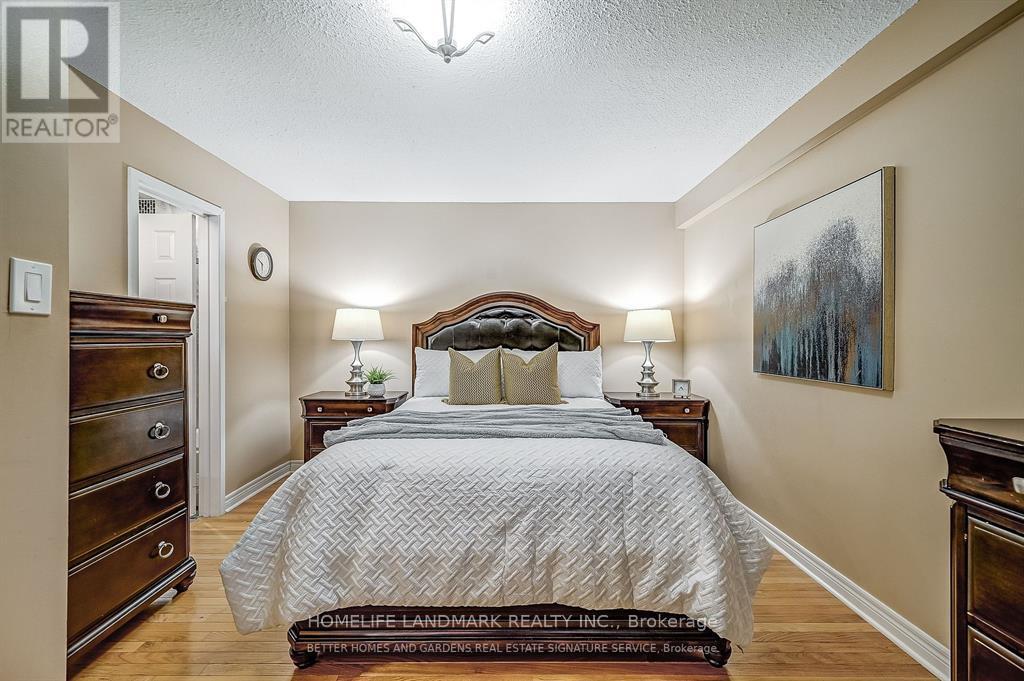 A bedroom with a large bed and a painting on the wall.