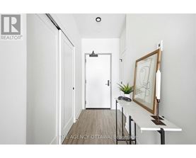 A hallway with a white door and a picture frame on a table.