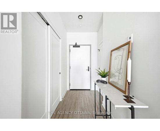 A hallway with a white door and a picture frame on a table.