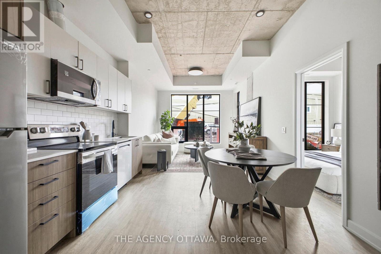 A modern kitchen with a dining table and chairs in the middle of the room.