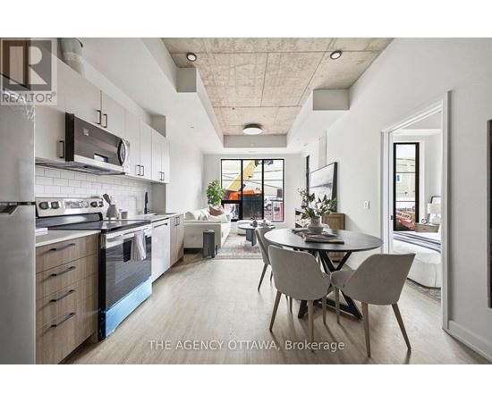 A modern kitchen with a dining table and chairs in the middle of the room.