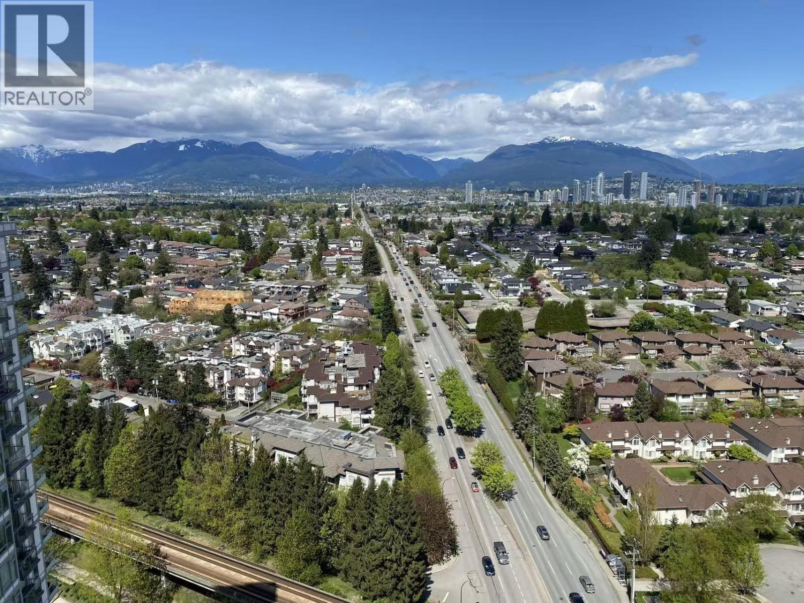 A cityscape with a highway running through it and mountains in the background.
