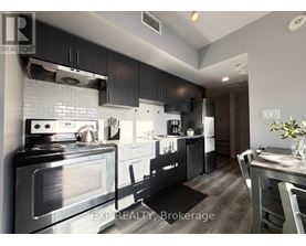 A modern kitchen with a stove top oven and a refrigerator.