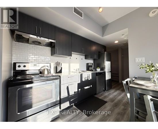 A modern kitchen with a stove top oven and a refrigerator.