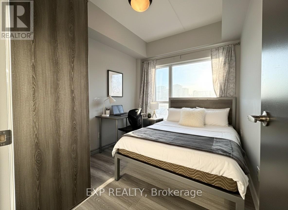 A bedroom with a bed, desk, and window.