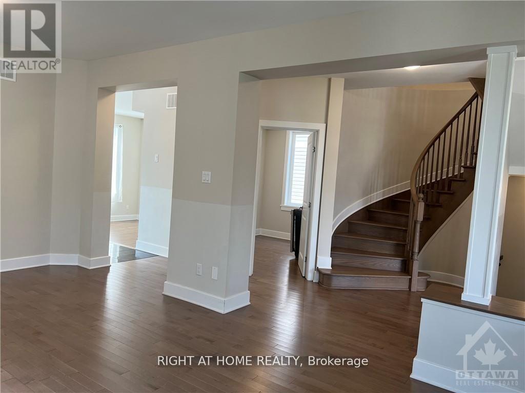 A spacious room with a staircase and a window.