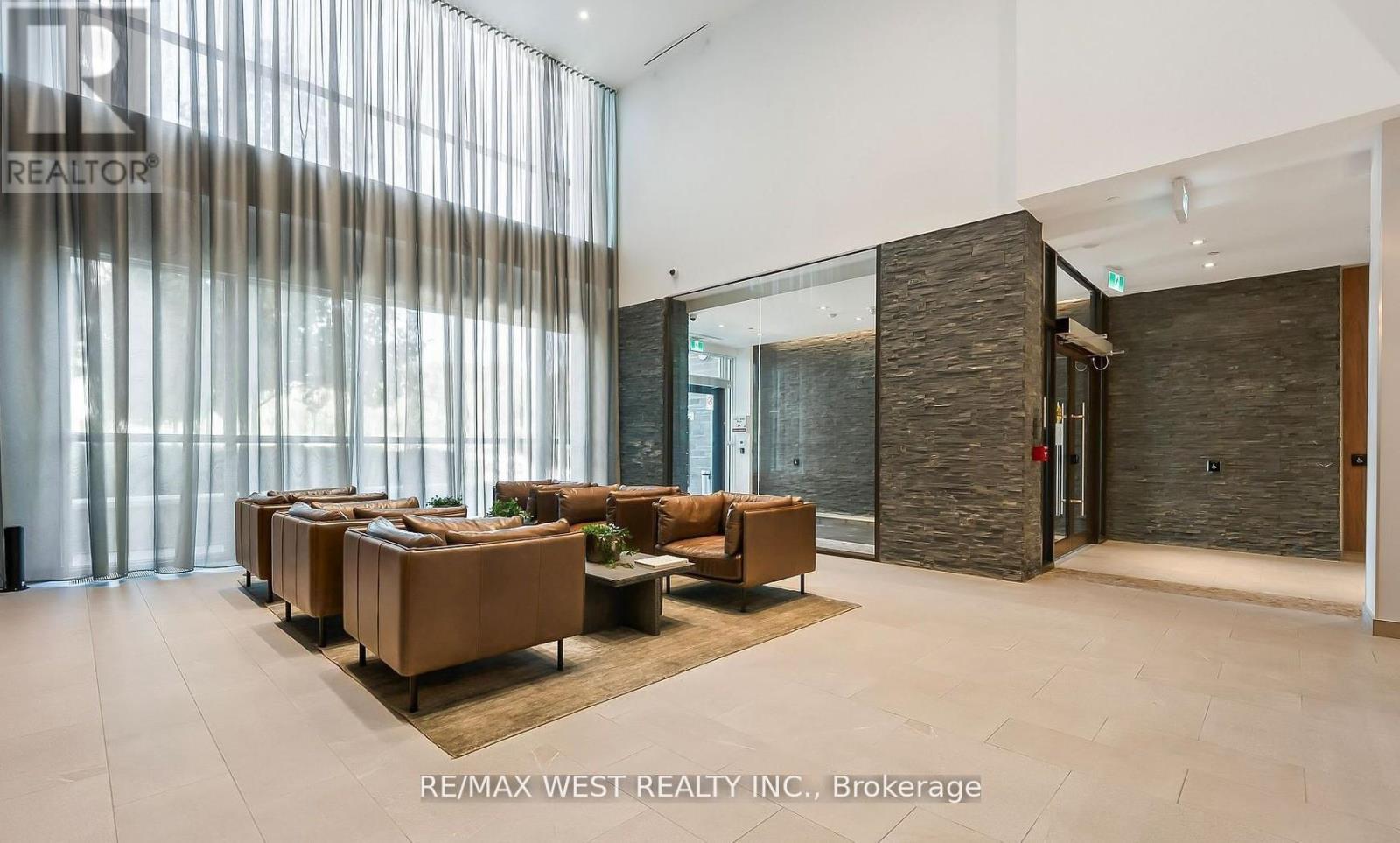 A spacious living room with a long couch and a glass wall.