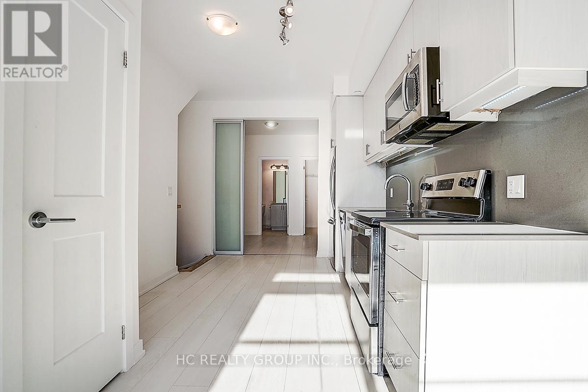 A white kitchen with a microwave on the counter.