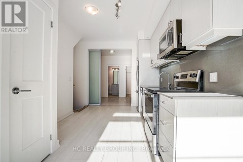 A white kitchen with a microwave on the counter.