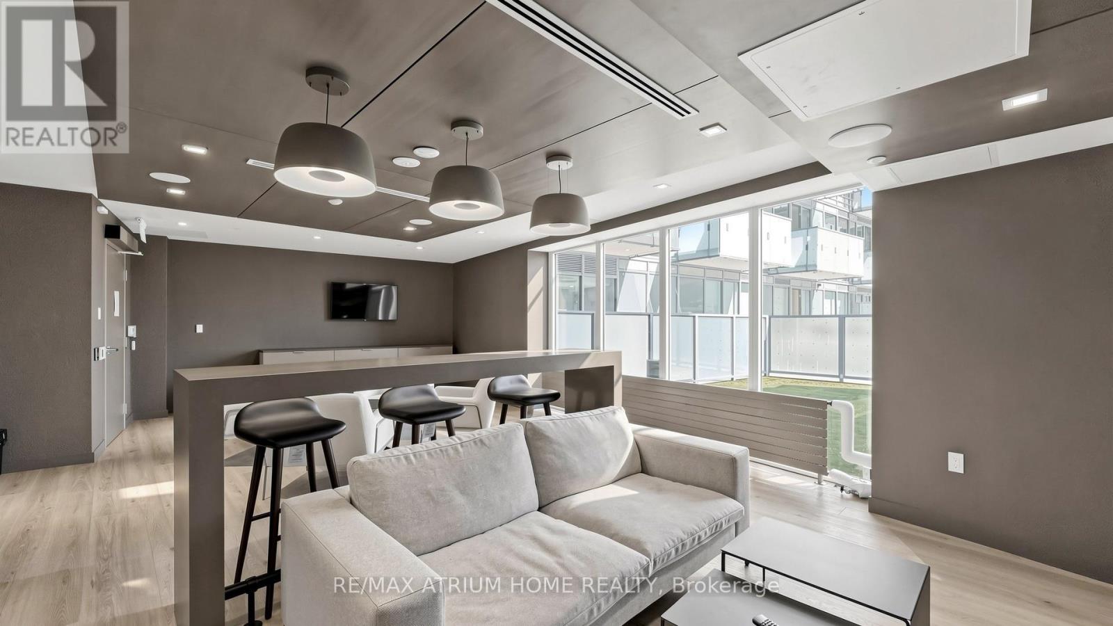 A modern living room with a grey sofa and a bar area.