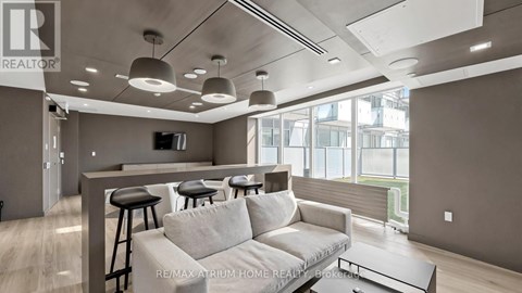 A modern living room with a grey sofa and a bar area.
