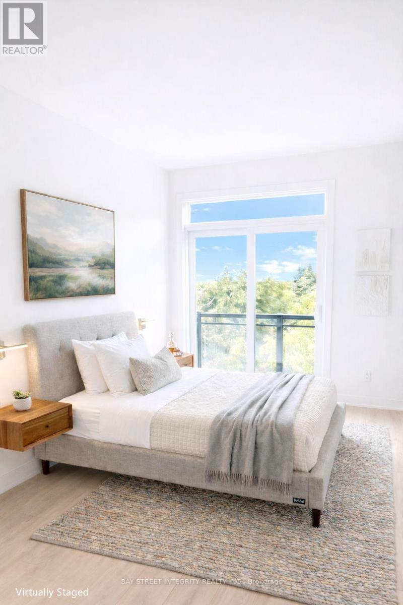 A spacious room with a large window and wooden flooring.