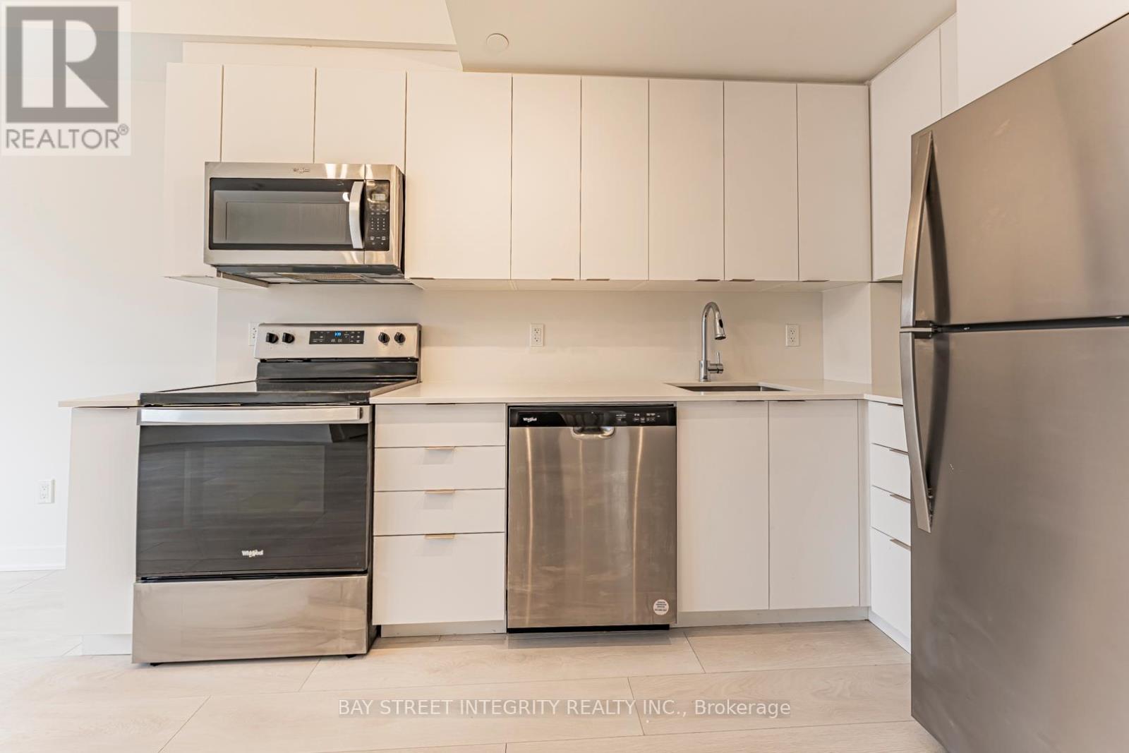 A kitchen with white cabinets and stainless steel appliances.