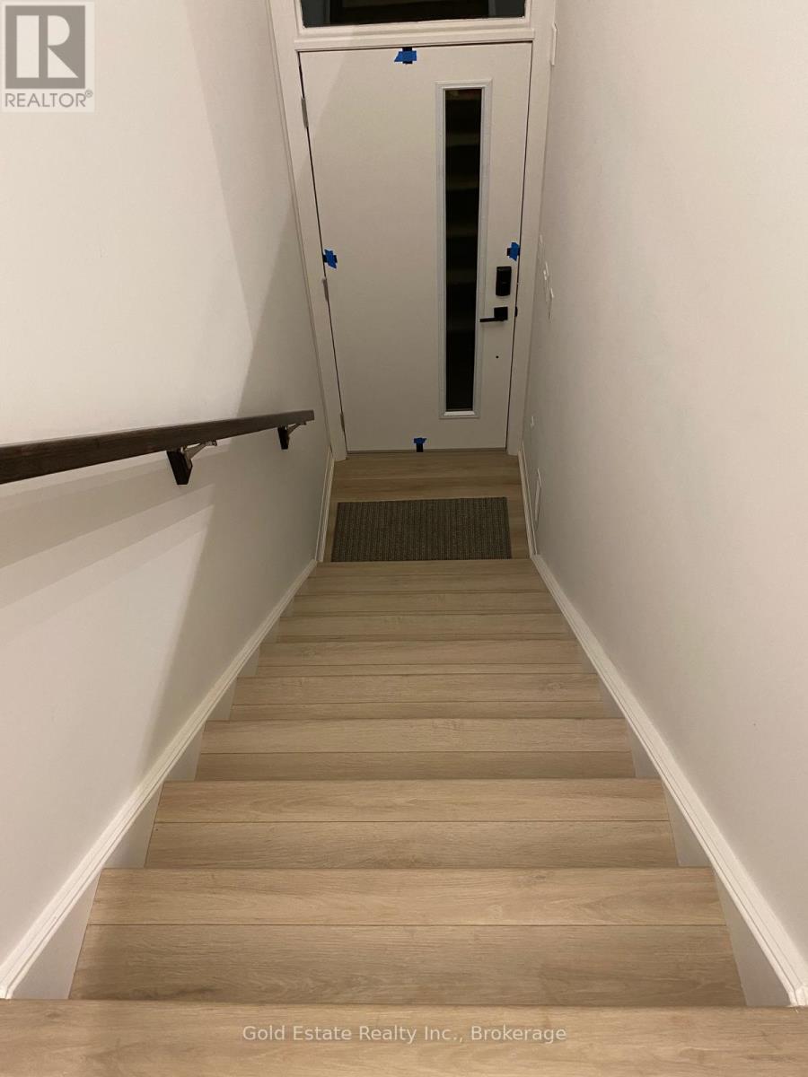 A hallway with a door at the end and a carpet on the floor.
