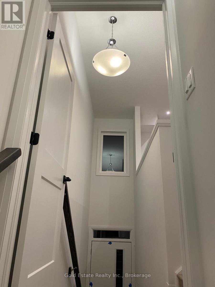 A white hallway with a light hanging from the ceiling.