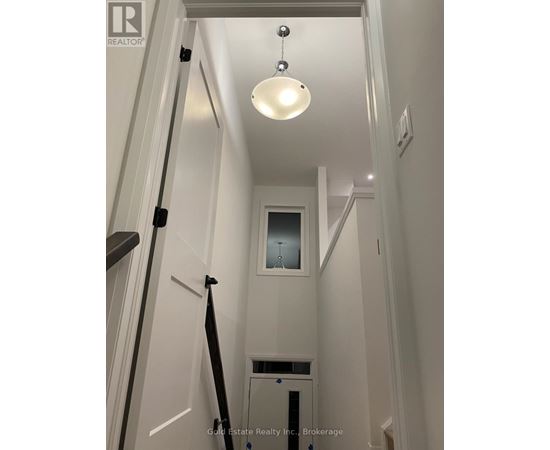 A white hallway with a light hanging from the ceiling.