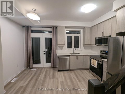 A kitchen with wooden floors and stainless steel appliances.