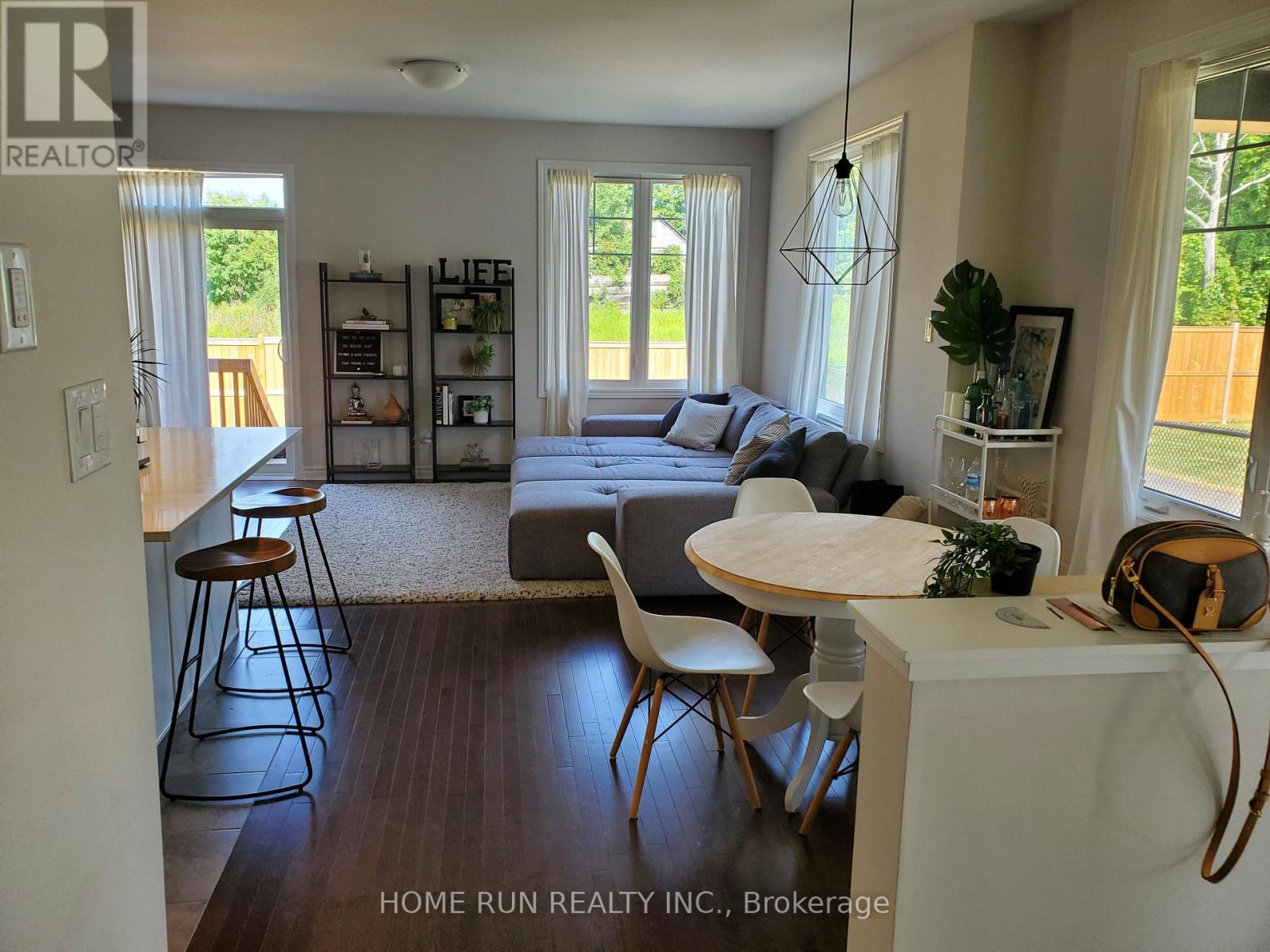 A living room with a couch, chairs, and a dining table.