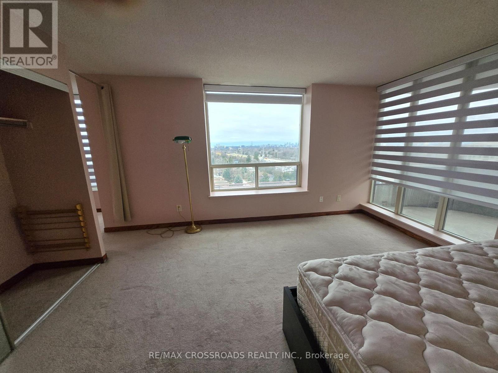 A bedroom with a large bed and a view of the city.